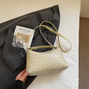 Gros plan détaillé d'un sac hobo tissé posé sur un blazer avec des accessoires de mode chics