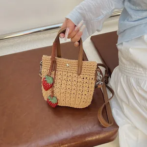 Sac fourre-tout en paille tressée avec poignées en cuir marron et pendentifs fraises