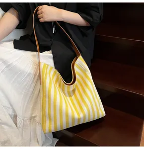 Chic large canvas tote bag featuring yellow and white stripes and brown leather straps