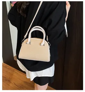 Détail du sac à main en paille tressée beige avec lanières en cuir blanc pour l'été