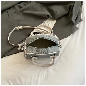 Détail du sac à bandoulière tissé gris montrant le compartiment intérieur et le zip