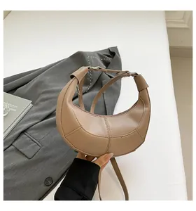 Détail du sac croissant kaki avec texture cuir grainé et bandoulière réglable
