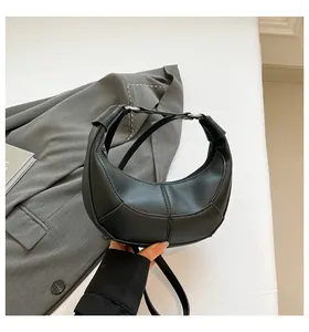 Détail du sac bandoulière croissant noir en cuir grainé avec coutures élégantes