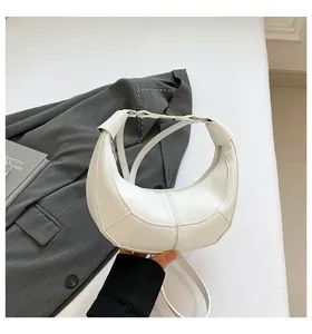 Détail du sac hobo en cuir grainé blanc montrant les coutures et la fermeture éclair
