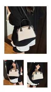 Détail du sac tissé crème avec poignées en cuir noir et bandoulière à ferrures argentées