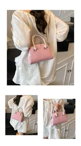 Vue détaillée du sac Boston rose tissé avec lanières en cuir blanc et fermeture argentée