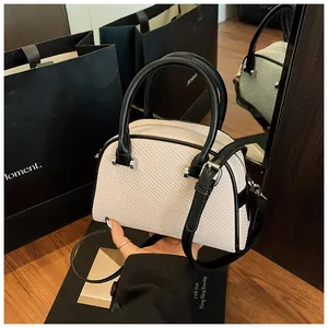 Détail du mini sac Boston blanc cassé à texture tissée avec lanières en cuir noir