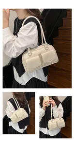 Detail der cremeweißen Schultertasche mit zwei Fronttaschen und glänzender Oberfläche