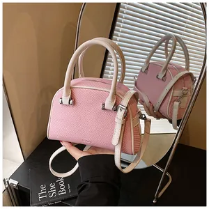 Détail du sac Boston tissé rose et blanc avec logo BOIAD et accents de poignée en cuir