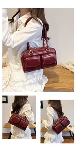 Detail der weinroten glänzenden Lederschultertasche mit zwei Vordertaschen und Retro-Stil
