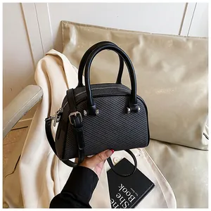 Vue détaillée du sac bandoulière noir tissé avec double poignée et garnitures argentées