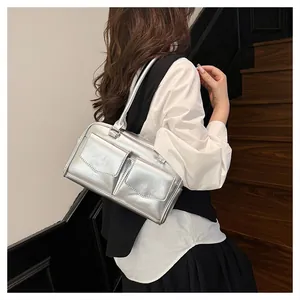 Nahaufnahme der silbernen Metallic-Schultertasche mit zwei Vordertaschen am Model