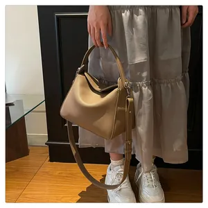 Détail du sac Lindy en cuir grainé marron avec finitions argentées porté par le mannequin