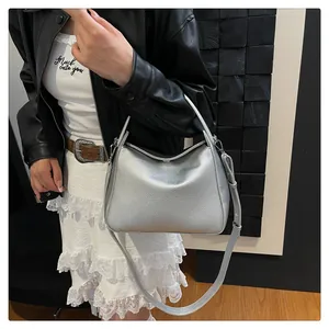 Sac Boston argenté grainé avec bandoulière réglable porté en bandoulière sur un mannequin