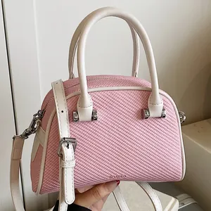 Petit sac carré tissé rose avec poignées en cuir blanc et détails argentés