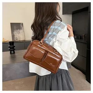 Detail der kaffeebraunen Schultertasche aus glänzendem Kunstleder mit zwei Vordertaschen