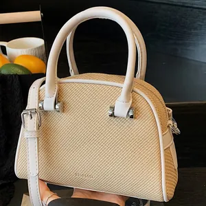 Sac à main en paille tressée avec bordure en cuir blanc et détails argentés