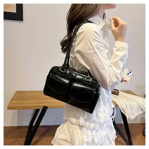 Detailansicht der schwarzen polierten Lederschultertasche mit Taschen auf weißem Hemd