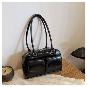 Detail der glänzenden schwarzen Leder-Schultertasche mit Frontklappen und Silberbeschlag