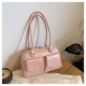 Details einer rosa glänzenden Schultertasche mit zwei Vordertaschen und silbernen Reißverschlüssen