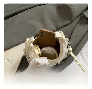Detailansicht der cremefarbenen Tasche mit Smartphone und Make-up im Innenfach
