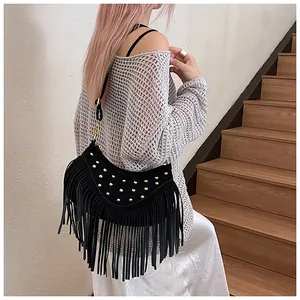 Close-up of black fringe crossbody bag with gold rivets and suede-like texture