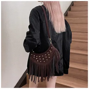Detail of dark brown suede hobo bag with gold rivets and long fringe tassels on bottom