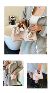 Detailansicht einer rosa Cloud-Tasche mit weißem Spitzenbesatz und Plüschhasen-Anhänger