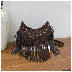 Detail of dark brown suede crescent bag with metallic studs and long tassel fringe