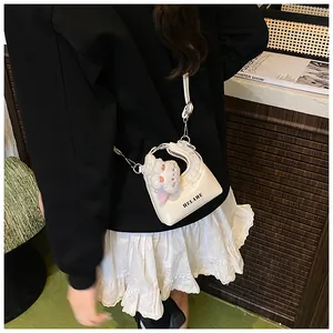 Weiße Mini-Tasche mit Spitzenbesatz und Plüsch-Anhänger an einem modischen Model-Outfit
