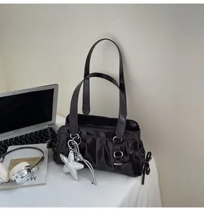 Detail of dark brown leather handbag with silver star charm and bow decoration