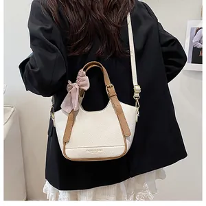 Sac seau beige à texture litchi avec bandoulière marron et foulard à pois roses