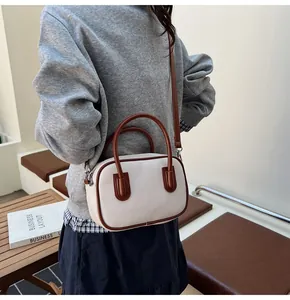 Detail of vintage white woven texture bag with brown leather trim and shoulder strap