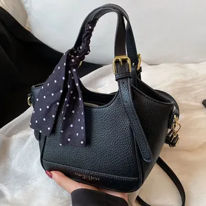 Sac seau noir en cuir litchi avec ferrures dorées et détail de foulard à pois