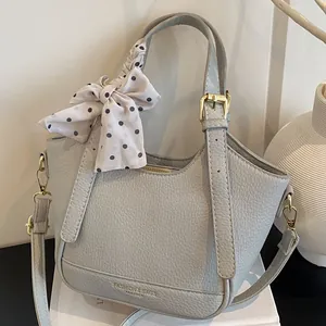 Sac seau gris en cuir grainé avec foulard à pois et détails métalliques dorés chic