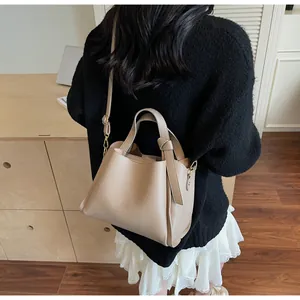 Detail of the litchi pattern leather texture and knot design on khaki bucket bag