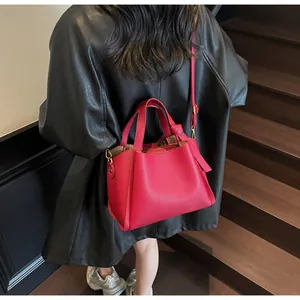 Detail of fuchsia leather bucket bag with top handles and golden hardware in retro setting