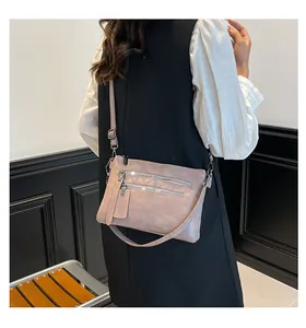 Vue détaillée du sac bandoulière en similicuir rose avec doubles fermetures éclair