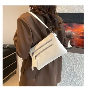 Détail du sac bandoulière blanc en cuir grainé avec deux fermetures éclair frontales
