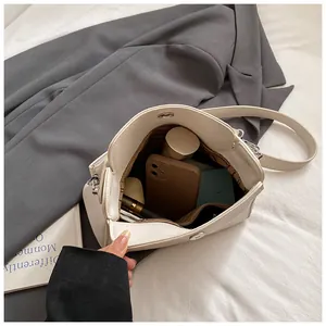 Vue macro montrant la grande capacité et le compartiment intérieur du sac seau beige