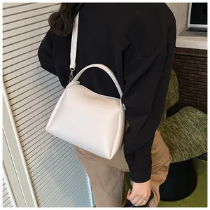Vue latérale détaillée d'un sac seau blanc cassé porté par un mannequin