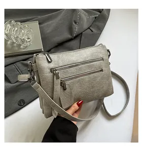 Détail du sac bandoulière en similicuir argenté avec doubles fermetures et compartiments