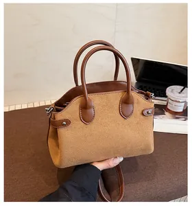 Détail d'un sac à main vintage patchwork avec rivets, doubles poignées et bandoulière réglable