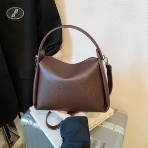 Sac seau minimaliste marron foncé avec texture lychee et finitions métalliques argentées