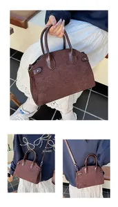Détails du sac marron foncé en cuir mat montrant les styles porté main et bandoulière