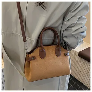 Détail du sac à main en daim caramel avec lanières en cuir et accents métalliques