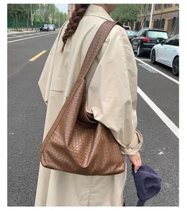 Detail of deep brown woven leather tote with large capacity and hobo bag texture