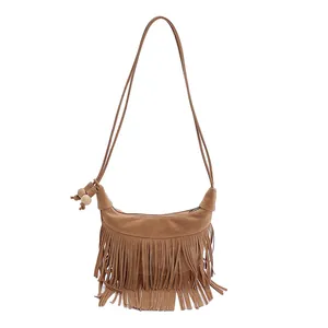 Sac bandoulière marron à franges avec fini daim et détails en perles de bois sur fond blanc