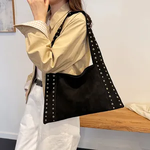 Chic black tote bag with gold rivets on strap and body, trendy motorcycle style crossbody