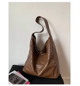Macro detail of brown woven leather texture on a spacious hobo tote shoulder bag